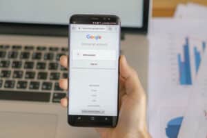 Homem segurando o celular mostrando as Melhores práticas de link building para evitar penalidades do Google