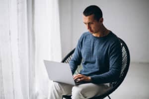 Homem usando o seu notebook aprendendo a como criar conteúdo que responde às perguntas dos usuários